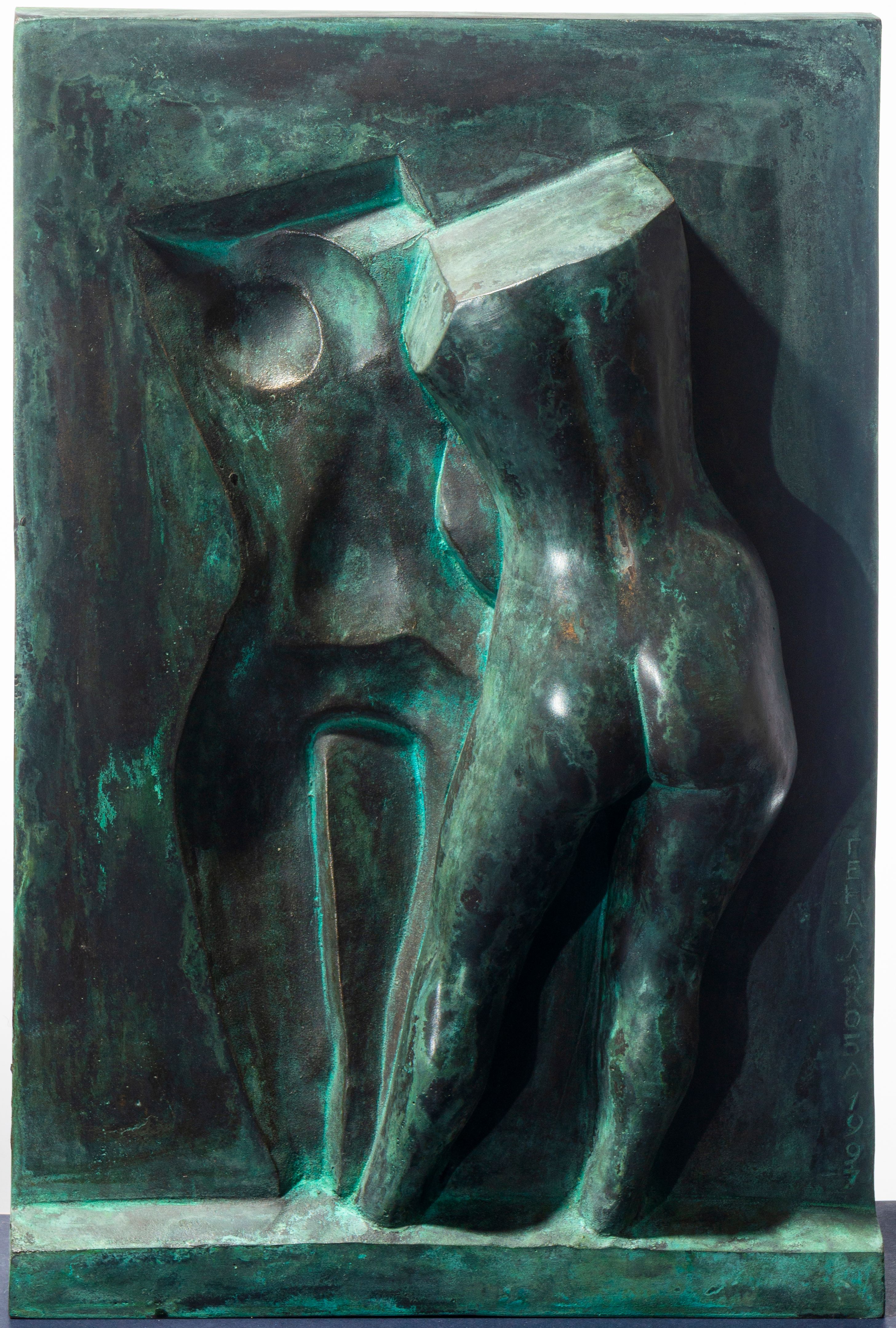 Bronze relief “A woman in front of the mirror”: a dark green-patinated female torso beside a hollowed, shallower reflection, set in a rectangular frame.