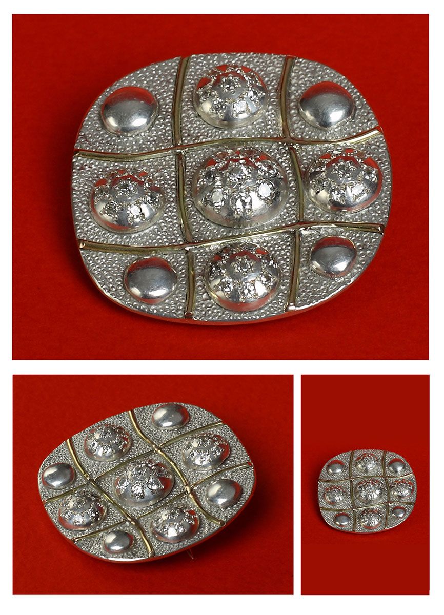 Brooch “Angelika”: an oval silver brooch with a grid of nine domed sections, some set with small stones, shown from three angles on red.