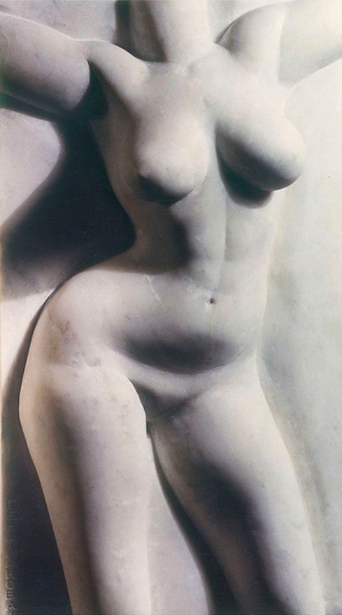 Marble high relief “Luda”: a white female torso with arms spread wide, smooth skin and soft shadows on a pale stone background.