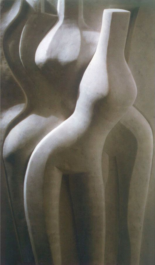 Marble high relief “Three figures”: three smooth, simplified standing female forms with narrow waists, overlapping in pale stone.