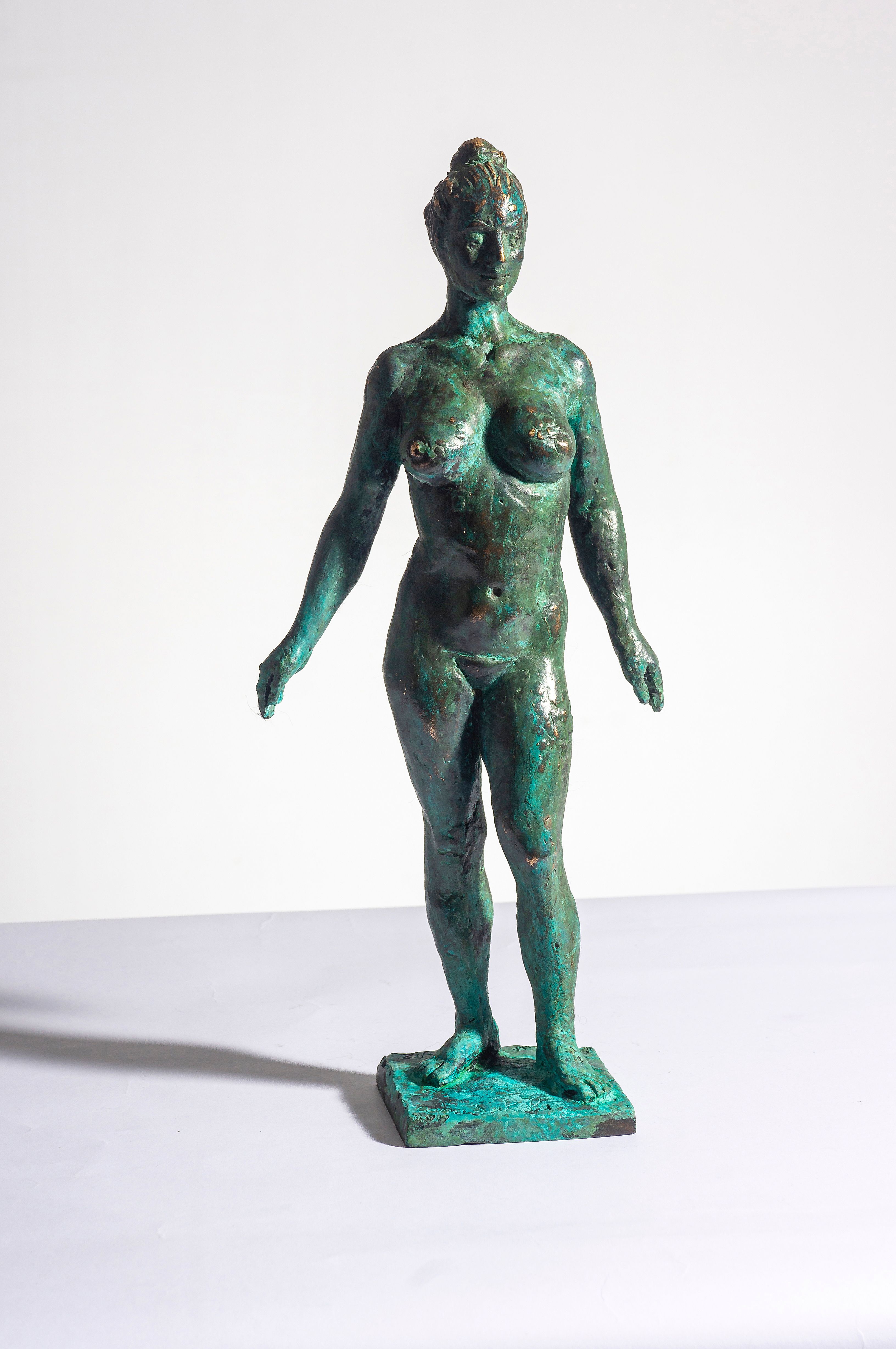 Bronze sculpture “Julia”: a small standing nude woman with arms slightly out, green patina, on a small square base.