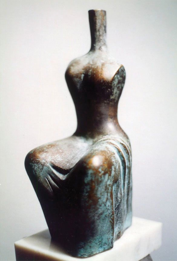 Bronze sculpture “Lake 1”: a seated, simplified female figure with a long thin neck and no face, dark brown with green patina, on a white marble base.