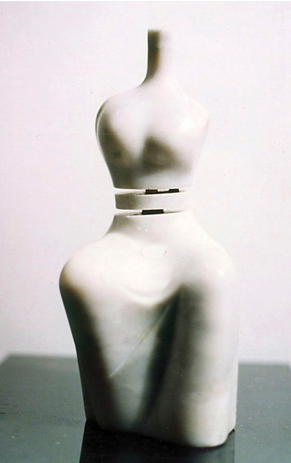 Marble sculpture “Lake 2”: a seated, simplified female figure with a long thin neck, split by a narrow gap at the waist, in white stone on a dark surface.
