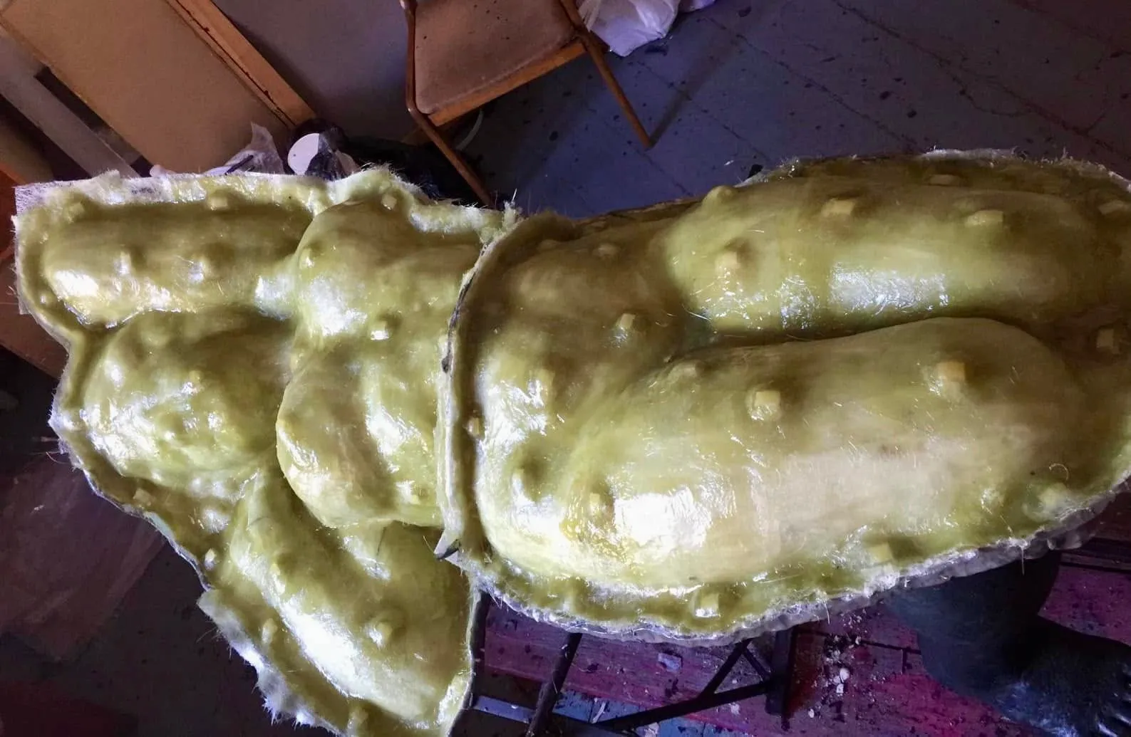 Green fibreglass mould sections covering the figure
