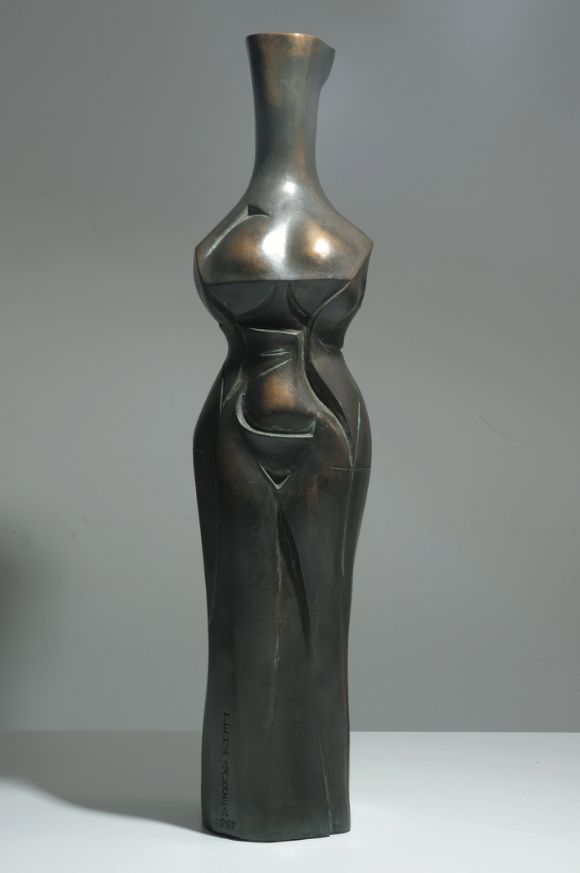 Bronze sculpture “Transparent autumn”: a tall, slim standing female figure with a long neck, narrow waist and long skirt-like lower body, dark brown.