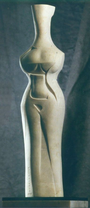 Marble sculpture “Transparent autumn”: a tall, slim standing female figure in pale stone with a long neck and carved lines on the body, on a dark base.