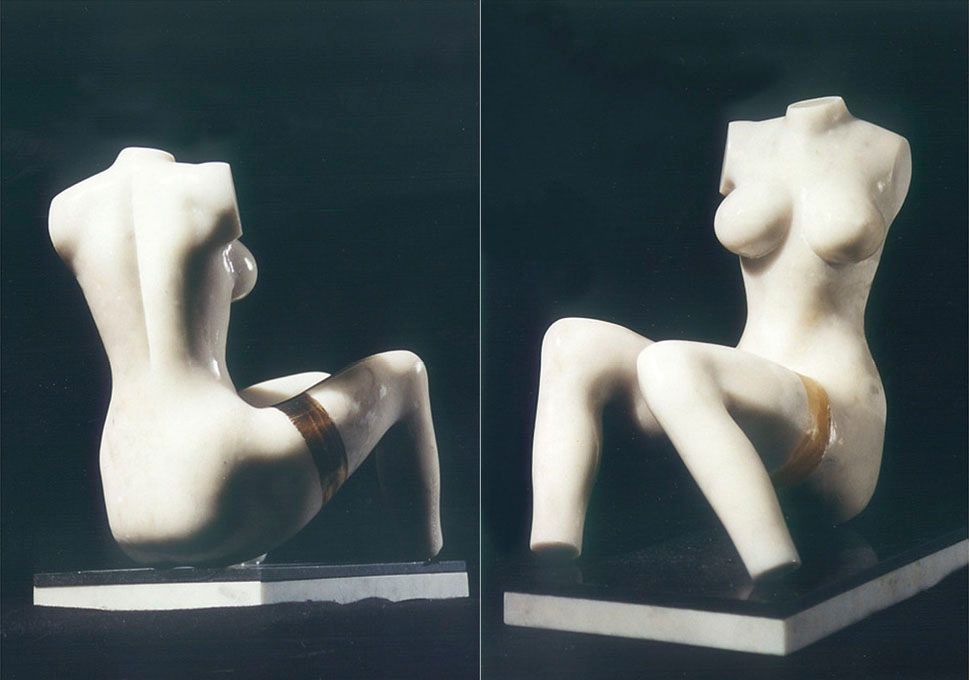 Marble sculpture “White Luda”: a white female torso with legs apart, with a thin gold-coloured band on one thigh, shown from the back and the front on a dark base.