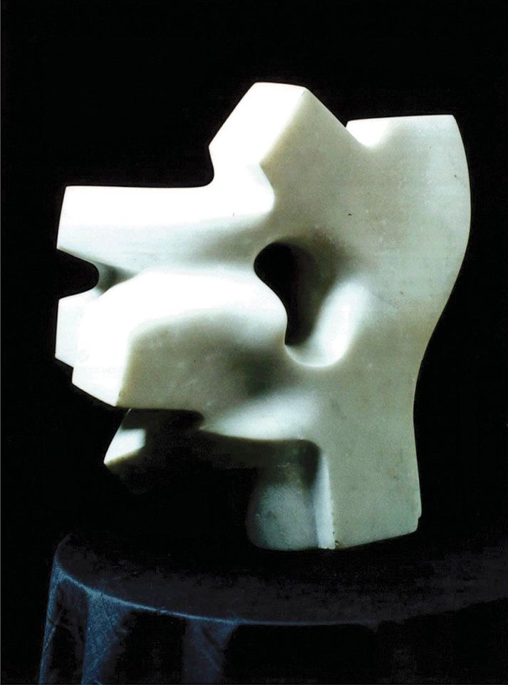 Marble sculpture “Wind”: an angular white form with a rounded hole in the middle and notched edges, on a dark draped stand.
